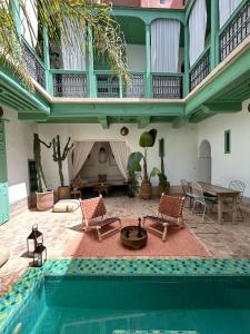 un salon avec une piscine et une maison dans l'établissement Riad dar Maloukti, à Marrakech