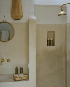 a bathroom with a shower with a sink and a mirror at Riad dar Maloukti in Marrakesh +50 photos
