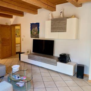 グンツェンハウゼンにあるFerienwohnung Näfeltの壁に薄型テレビが取り付けられたリビングルーム