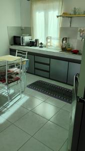 eine Küche mit einer Theke, einem Tisch, einem Tisch und Stühlen in der Unterkunft Bella Melody's Paradise in Flic-en-Flac