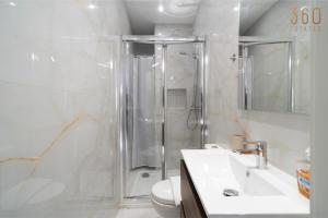a bathroom with a shower and a toilet and a sink at Seaside Comfort in St'Pauls Bay steps from the Sea by 360 Estates in St Paul's Bay +56 photos