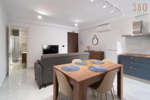 a kitchen and dining room with a wooden table and chairs at Seaside Comfort in St'Pauls Bay steps from the Sea by 360 Estates in St Paul's Bay