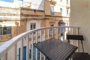 a balcony with a bench on a balcony at Seaside Comfort in St'Pauls Bay steps from the Sea by 360 Estates in St Paul's Bay