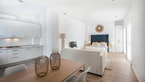 Sala de estar blanca con sofá y mesa en iloftmalaga Studio Apartments, en Málaga