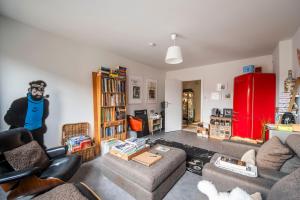 a living room filled with furniture and a red refrigerator at Chez RG in Bruges