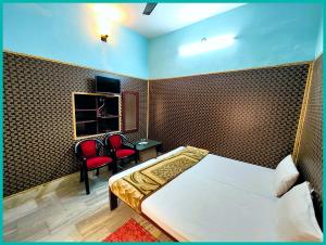 a bedroom with a bed and a desk and chairs at Hotel Shilpa Teerth Palace Guest House Near Vishwanath Temple - #Fully Air Conditioned Rooms #Restaurant And Wi-fi Facility - Best Prmium Hotel In Varanasi in Kashi
