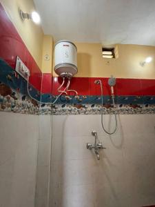 a bathroom with a shower with a light on the wall at Danda Nagraja Homestay in Byānsghāt