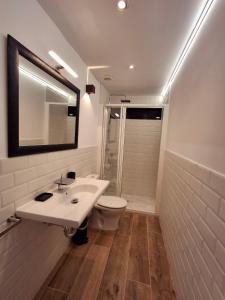 a bathroom with a sink and a toilet and a mirror at Can Pairot in Pujals dels Cavallers