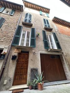an old building with two wooden doors and windows at La dimora di Pino in Ripa