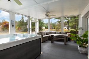 a large living room with a tub and a couch at 3BR Lake Luzerne Retreat with Game Room & Hot Tub in Lake Luzerne