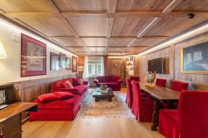 a living room with red chairs and a wooden ceiling at St Moritz Square 2 bedr Alpin Elegance in St. Moritz