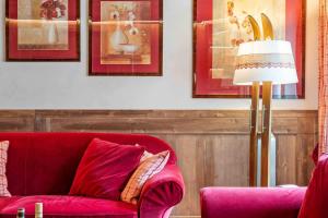 a red couch in a living room with pictures on the wall at St Moritz Square 2 bedr Alpin Elegance in St. Moritz