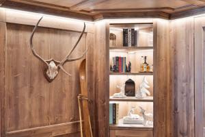 a book shelf with a deer head and antlers on it at St Moritz Square 2 bedr Alpin Elegance in St. Moritz