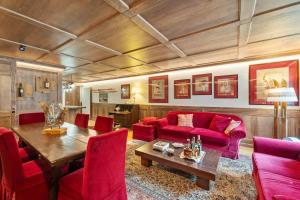 a living room with a red couch and a table at St Moritz Square 2 bedr Alpin Elegance in St. Moritz