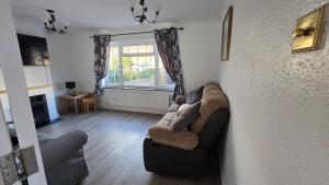 un salon avec un canapé et une fenêtre dans l'établissement Spencer , 4 bed slp 8 semi in Lee On The Solent, à Lee-on-the-Solent
