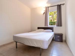 a bedroom with a white bed with a window at Vacancéole - Résidence Lisa Maria in Favone +60 photos