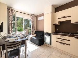 a kitchen and living room with a table and a couch at Vacancéole - Résidence Lisa Maria in Favone