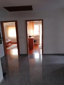 an empty room with two doors and a living room at Apartman Ružica in Tomislavgrad