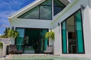 a house with glass doors and a swimming pool at Modern 2BR Pool Villa - Near Ao Nang Beach in Ao Nang 