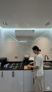 eine Frau steht in einer Küche und bereitet Essen vor in der Unterkunft Farmhouse-Villa--فيلا-المزرعة in Hatta