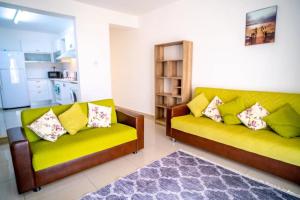 ein Wohnzimmer mit 2 gelben Sofas und einer Küche in der Unterkunft Spacious Three-Bedroom Apartment A3 in Sanctuary Cove site in Kyrenia