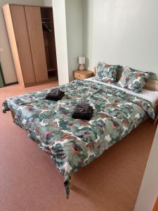una cama con un edredón floral y dos bolsas encima en Maidla Hostel, en Maidla 5 fotos más