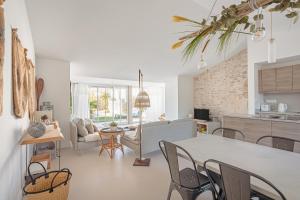 a kitchen and living room with a table and chairs at Villa L’hirondelle in La Michelière