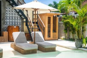 a pair of chairs and an umbrella on a pool at Kano Twin in Canggu +68 photos