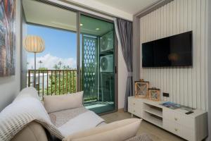 a living room with a couch and a large window at Ozone Condominium BangTao Laguna Area in Phuket