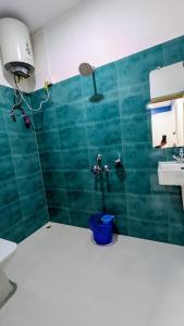 a green tiled bathroom with a sink and a shower at Naku homes in Dirang Dzong