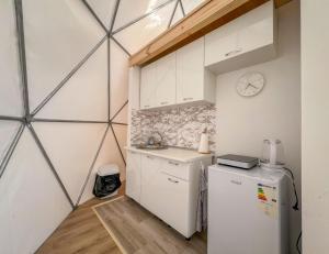 uma cozinha com um frigorífico e um relógio na parede em Durmitor Glamp em Žabljak mais 52 fotografias