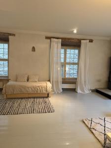 a bedroom with a bed and two windows at Medieval Old Town Gem with Sauna and Fireplace in Tallinn