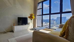a living room with a tv and a large window at Trion Sky Suite KL in Kuala Lumpur