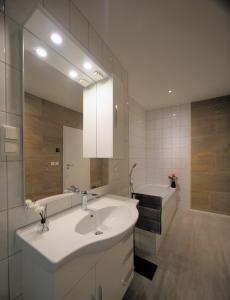 a bathroom with a sink and a tub and a mirror at Appartment Junior Suite in Springe