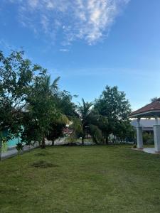 a park with palm trees and a gazebo at Roomstay Bintong in Kangar +18 photos