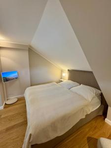 a bedroom with a large bed in a attic at NEU Keitum - Moderne Gemütlichkeit unter Reet in Sylt +6 photos