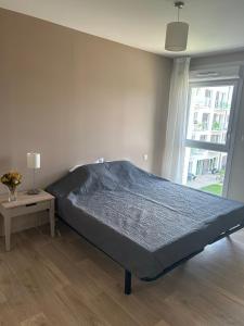 uma cama grande num quarto com uma janela em Wattrelos Appart'S em Wattrelos