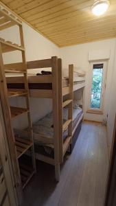 a room with three bunk beds in a cabin at Lukasowy domek w Puszczy Noteckiej in Biala