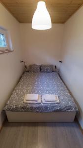 a bedroom with a bed with two towels on it at Lukasowy domek w Puszczy Noteckiej in Biala