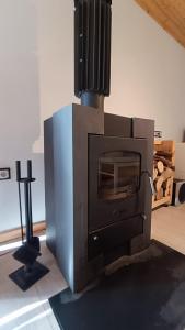 a woodburning stove in a room with a cross at Lukasowy domek w Puszczy Noteckiej in Biala