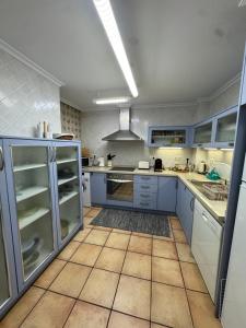 サンタ・ポラにあるApartamento CAMPAのタイルフロアのキッチン(青いキャビネット付)