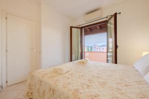 a bedroom with a large bed with a large window at Small paradise a few meters from the sea in Le Vecchie Saline +22 photos