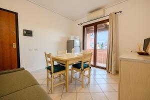 a living room with a table and chairs and a kitchen at Small paradise a few meters from the sea in Le Vecchie Saline