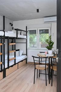 a room with bunk beds and a table and a table and chairs at Industrial Hostel Vila Jovana in Odžaci