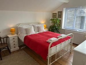 a bedroom with a white bed with a red blanket at Hanushka in Hastings