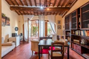 a living room with a table and a book shelf at Antiche Dimore Del Vescovado in Murlo
