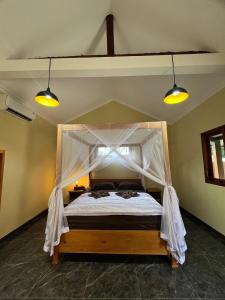 a bedroom with a bed with a canopy at Gifal Surf Camp & Cottage in Wainapal