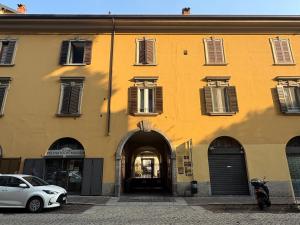 a yellow building with a car parked in front of it at L'Albero in Bergamo