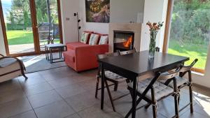a living room with a table and a fireplace at Dom uKromki z kominkiem i widokiem na Śnieżkę in Sosnówka