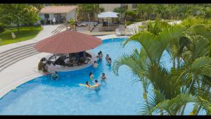 a group of people in a swimming pool with an umbrella at Casa Andina Select Zorritos Tumbes in Zorritos